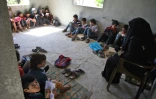 Une institutrice donne des cours à des enfants déplacés dans une villa en construction ransformée en école, dans les territoires insurgés d'Alep, le 24 septembre 2018