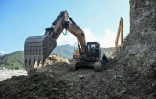 Des ouvriers dégagent une route avec des pelleteuses le long de la rivière Trishuli dans le district de Nuwakot, au Népal, le 1er octobre 2026