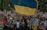 Des manifestants brandissent un drapeau ukrainien lors d’une manifestation contre la décision du président ukrainien de limoger le ministre de la Défense Mykhaïlo Fedorov, à Kiev le 18 juillet 2026