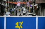 Des personnes dans la rue d'un quartier barricadé, le 7 avril 2020 à Wuhan, dans la province chinoise du Hubei
