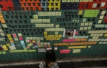 Une femme ajoute un post-it sur un mur affichant des messages de protestation contre le gouvernement et le projet de loi favorisant l'extradition vers la Chine, Ă Hong Kong le 10 juillet 2019