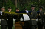Des militaires de la garde d’honneur ukrainienne tiennent des drapeaux nationaux au-dessus des cercueils contenant les dépouilles d’Andriy Melnyk, mort en 1964 et chef d’une branche de l’Organisation des nationalistes ukrainiens (OUN) lors de leur cérémonie de réinhumation au cimetière militaire national près de Kiev, le 25 mai 2026