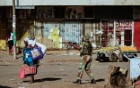 Un soldat zimbabwéen met en joue une femme à Harare, après des affrontementsentre forces de l'ordre et partisans de l'opposition qui dénoncent des fraudes après les élections générales, le 1er août 2018 à Harare