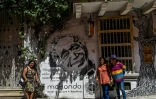 Des touristes posent devant une peinture murale représentant Gabriel GArcia Marquez à Carthagène le 22 mai 2016