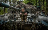 Un soldat ukrainien pose sur son char T72 sur la ligne de front près de la ville de Bakhmout, en Ukraine, le 30 avril 2023