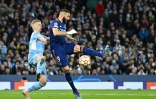 L'attaquant Karim Benzema devance le milieu de terrain ukrainien de Manchester City Oleksandr Zinchenko  et réduit le score pour le Real Madrid, lors de leur demi-finale aller de la Ligue des Champions, le 26 avril 2022 à l'Etihad Stadium