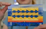 Une planche d'un timbre ukrainien représentant un tracteur remorquant un char russe sous un ciel jaune, le 28 juillet 2022 à Kiev