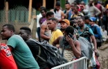 Des migrants font la queue pour se faire enregistrer à leur arrivée au village de Bajo Chiquito, dans la province du Darien, le 22 août 2021 au Panama