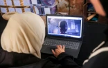 Une membre de l'association Mayasem pour la culture et les arts examine des images sur un ordinateur portable,au centre de stockage du patrimoine culturel à Khan Younès, le 11 juillet 2026 dans le sud de la bande de Gaza