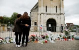 Des gens devant un mémorial improvisé devant l'église de Saint-Etienne du Rouvray, le 27 juillet 2016