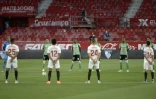 Les joueurs de Séville (blanc) et du Betis (vert) observent une minute de silence en hommage aux victimes du coronavirus, le 11 juin 2020 à Séville