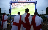 Des fans anglais regardent leur équipe perdre contre l'Islande dans la fan zone du Champ-de-Mars à Paris le 27 juin 2016