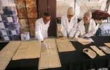 Des membres de l'association Mayasem pour la culture et les arts, examinent des documents anciens, le 11 juillet 2026 à Khan Younès, dans le sud de la bande de Gaza