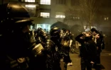 Un manifestant utilise du sérum physiologique pour atténuer les effets des gaz lacrymogènes alors qu'il fait face à la police anti-émeute lors d'une manifestation à Lyon, dans l'est de la France, le 20 mars 2023 ( AFP / JEFF PACHOUD )