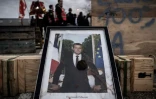 Un portrait d'Emmanuel Macron posé au sol dans une manifestation contre la réforme des retraites, à la centrale nucléaire du Blayais, le 21 mars 2023 à Blaye (Gironde) ( AFP / PHILIPPE LOPEZ )