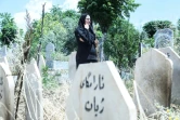 L'avocate féministe Rozkar Ibrahim près d'une pierre tombale où figure l'expression "tombe de vie" dans un carré reservé aux victimes de féminicides au cimetière de Siwan à Souleimaniyeh au Kurdistan autonome d'Irak le 17 mai 2024