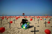 Un homme prépare une cérémonie d'hommage aux victimes du Covid-19, sur la plage de 
Copacabana à Rio de Janeiro (Brésil), le 8 août 2020