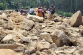 Des membres de la famille de villageois disparus sont présents sur le site d'un glissement de terrain au village de Mulitaka, dans la province d'Enga en Papouasie-Nouvelle-Guinée, le 26 mai 2024