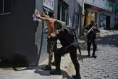 Un membre de la police militaire fouille un suspect pendant une opération contre le trafic de drogue dans la favela de Jacarezinho, le 19 janvier 2022 à Rio de Janeiro, au Brésil