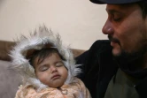 Khalil Sawadi tient dans ses bras sa petite nièce Afraa, sauvée des décombres du tremblement de terre de février 2023, à son domicile de Jindayris, au nord-ouest de la province d'Alep, le 2 février 2024 en Syrie