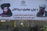Des combattants talibans patrouillent à bord d'un véhicule devant un panneau portant des portraits du mollah Omar et Jalaluddin Haqqani, tous deux défunts, sur une route de Kaboul le 9 septembre 2021