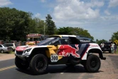 Le champion en titre Stéphane Peterhansel au volant de sa Peugeot arrive pour un check-up technique à Luque, le 30 décembre 2016