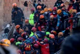 Des secouristes évacuent un survivant extrait des décombres d'un immeuble effondré durant un séisme à Elazig, dans l'est de la Turquie, le 25 janvier 2020
