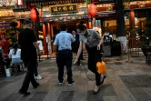 Une employée pulvérise du désinfectant à l'entrée d'un restaurant, le 6 juin 2022 à Pékin