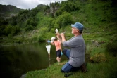 Dirk Schmeller, enseignant-chercheur et Pauline Benzi, étudiante, prélèvent des échantillons d'eau dans le lac Labant, le 23 juin 2022 à Aulus-les-Bains, en Ariège