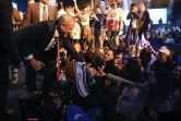 Benny Gantz (G), chef de la formation centriste israliénne "Bleu-Blanc", salue la foule lors d'un rassemblement électoral dans la ville israélienne de Tel Aviv (ouest), le 29 février 2020 