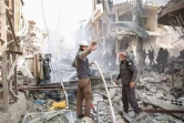 Des secouristes syriens des Casques Blancs tentent d'éteindre un feu après une frappe aérienne à Hamouria près de Damas au cours de laquelle au moins 16 civils sont morts et des dizaines de personnes ont été blessées, le 25 mars 2017