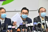 Le militant prodémocratie Alvin Yeung (c) montre l'avis de disqualification de sa candidature aux législatives lors d'une conférence de presse, le 30 juillet 2020 à Hong Kong