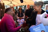 La Première ministre, Elisabeth Borne (d), distribue des tracts de campagne à des habitants, le 28 mai 2022 à Aunay-sur-Odon, dans le Calvados