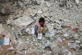 Une enfant palestinienne cherche des objets à récupérer dans les décombres d'une maison détruite par un bombardement israélien, le 16 janvier 2024 à Khan Younès, dans la bande de Gaza