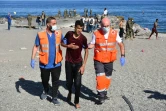 Des membres de la Croix rouge assistent un migrant arrivé à la nage à l'enclave espagnole de Ceuta, le 18 mai 2021
