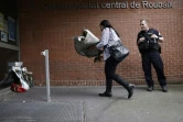Une femme dépose un bouquet de fleurs devant le commissariat de police de Roubaix (Nord) en homme aux policiers tués dans un accident de la route, le 21 mai 2023
