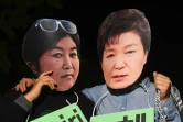 Des manifestants portant des masques de la présidente de Corée du sud Park Geun-Hye (d) et de son ex-confidente Choi Soon-Sil (g), dénoncent les liens entre elles lors d'un rassemblement à Séoul, le 27 octobre 2016