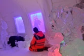 Un employé apporte la touche finale à une pièce du Arctic Snow Hotel, un hôtel fait de glace, le 17 décembre 2020 à Rovaniemi, en Laponie finlandaise