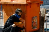 Un manifestant cherche refuge derrière une poubelle le 8 mars 2021 à Rangoun (Birmanie)