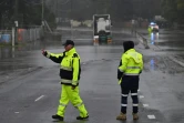 Des personnels des services d'urgence se tiennent sur une route inondée à Sydney le 4 juillet 2022