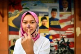 Une habitante de Kuala Lumpur montre l'encre sur son doigt après son vote le 9 mai 2018