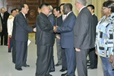 Photo non datée fournie par l'agence nord-coréenne Kcna le 28 juillet 2013 du leader nord-coréen Kim Jong-Un (c) accueillant le vice-président ougandais Edward Kiwanuka Ssekand à Pyongyang