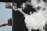 Des personnes travaillent sur la fusée Starship près de la rampe de lancement avant son quatrième vol d'essai depuis la base spatiale Starbase de SpaceX à Boca Chica, au Texas, le 4 juin 2024
