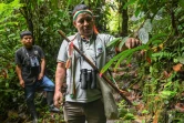 Un garde environnemetal indigène observe une plante dans la réserve El Gran Sabalo, près d'El Diviso, dans le département du Narino, en Colombie, le 31 août 2024