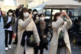 Des touristes portent des masques de protection contre le Covid-19 dans les rues de Milan, le 28 février 2020 