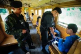 Des soldats controlent les passagers du train de 12H33, le 21 novembre 2016 à Narathiwat dans l'extrême sud de la Thaïlande