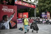 Un agent de nettoyage passe devant une affiche électorale d'Alexis Tsipras, battu lors des élections grecques du 7 juillet 2019 