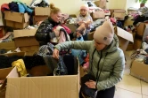 Des déplacées ukrainiennes cherchent des vêtements dans des cartons dans un centre d'aide à Lviv, le 11 avril 2022 en Ukraine