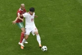 L'attaquant iranien Sardar Azmoun tente de se défaire du marquage du Marocain Karim El Ahmadi à Saint-Pétersbourg, le 15 juin 2018