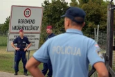 Forces de sécurité hongroises (face) et croate (de dos) me 20 septembre 2015 à Beremend à la frontière de la Hongrie et de la Croatie